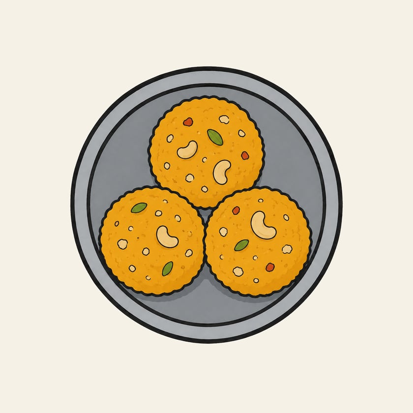 Illustration of three yellow laddoos studded with nuts in a steel bowl